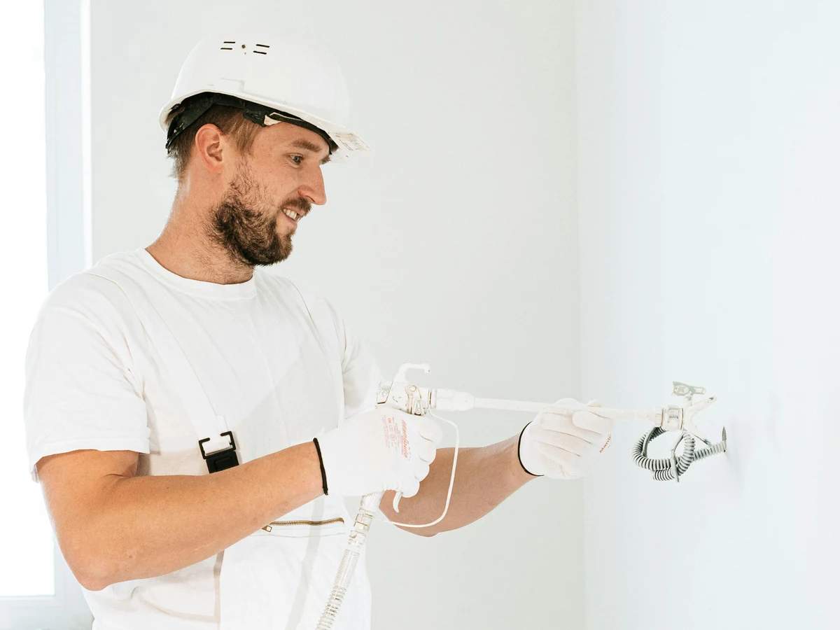 Professional painter examining surfaces for a Winchester house painting quote